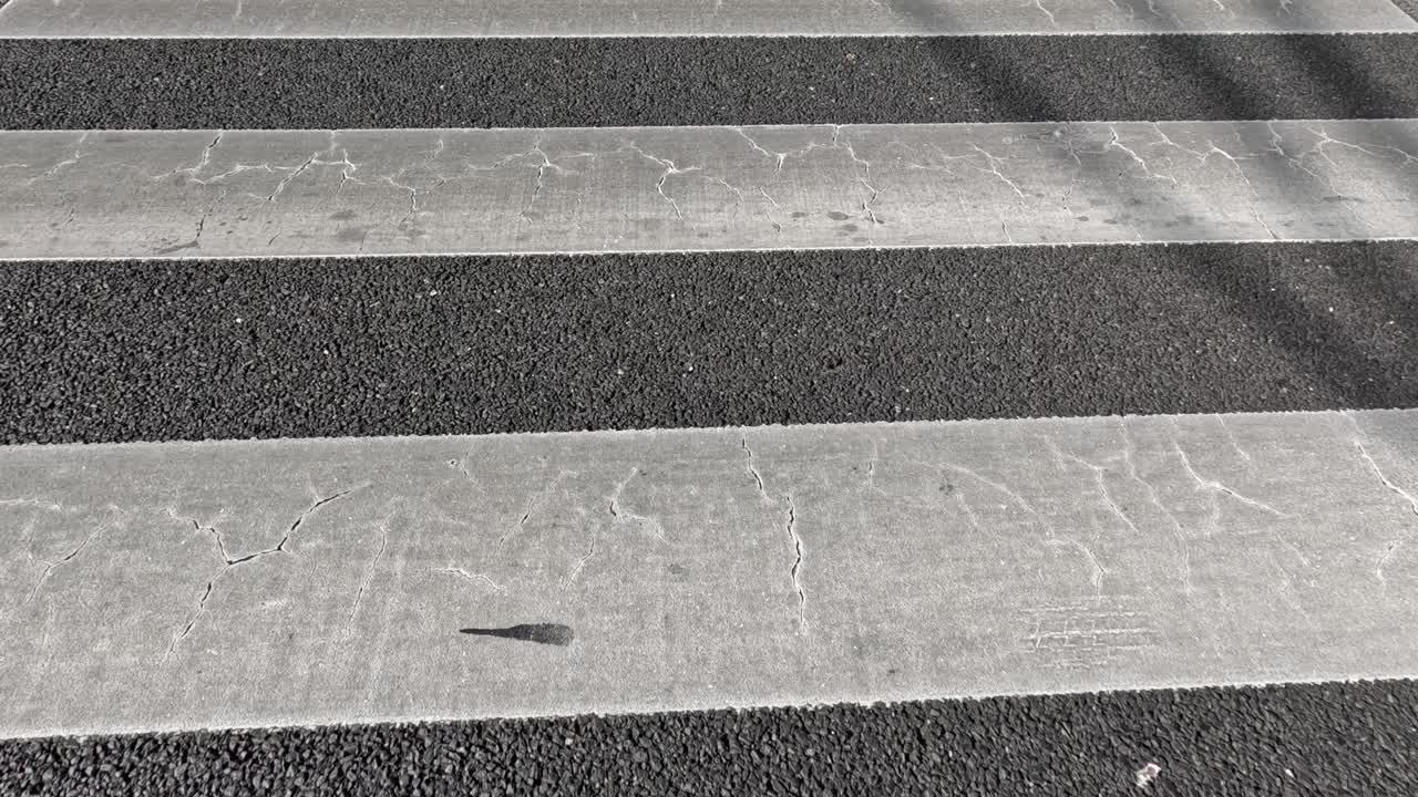 sombra de una persona caminando a través del cruce de cebras