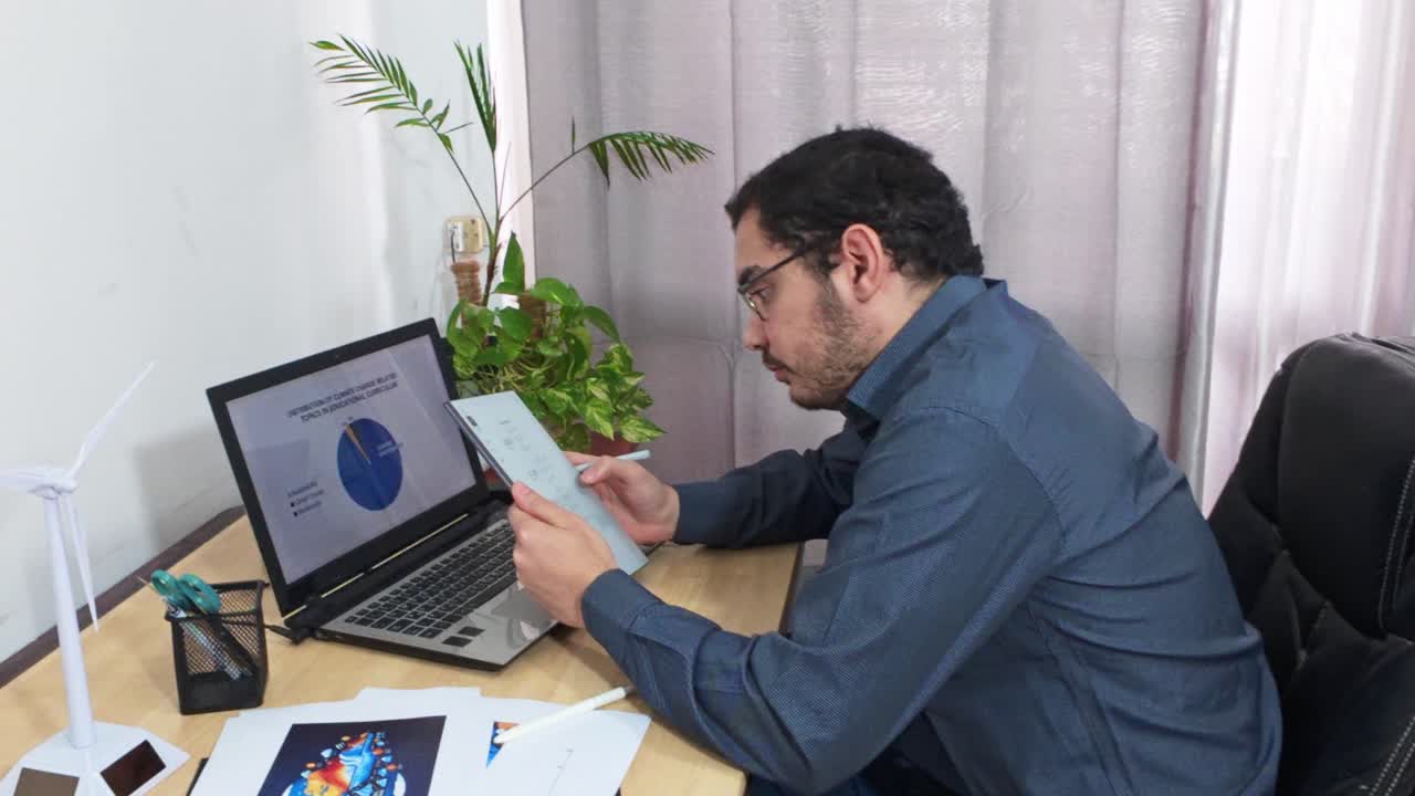 Engineer Analyzing Climate Change Data on Laptop and Tablet
