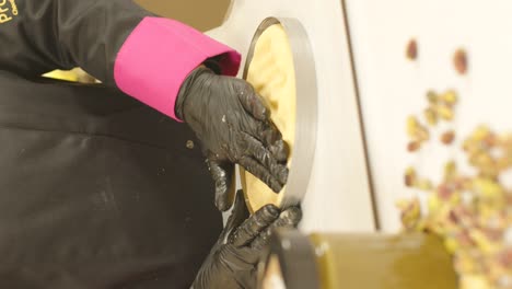 manos enguantadas dando forma a la masa de pastel en una bandeja para hornear