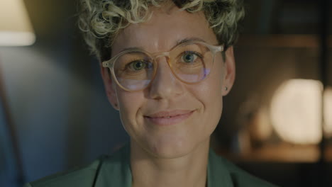smiling woman with glasses in a warm indoor setting