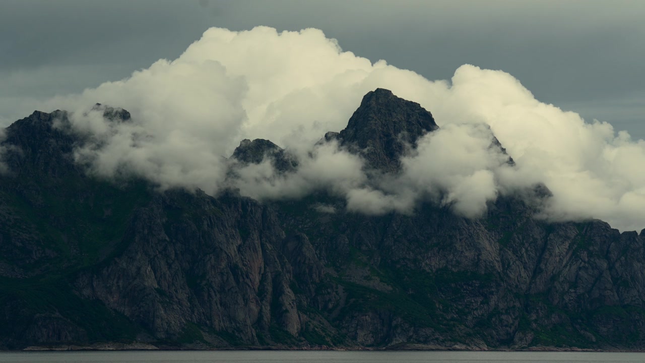 Clouds Settle Over Mountains Along The Coast Of Norway With Shifting Light.
