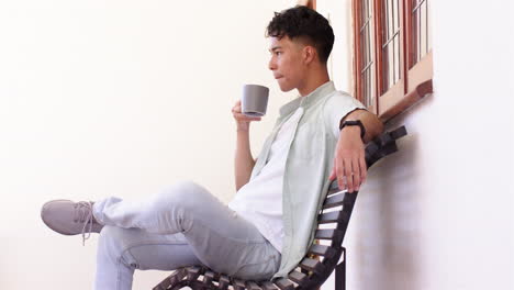 relaxing on bench, man holding coffee mug and looking away thoughtfully