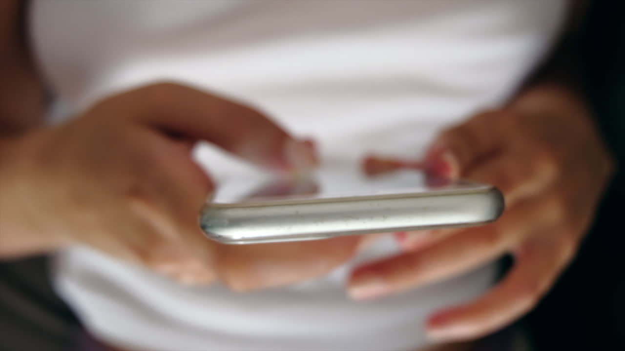 Close up of a woman lying on a couch scrolling on her phone