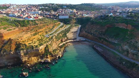 Aerial-shot-by-drone-of-cliff-overlooking-the-sea-with-a-mountain-road-with-passing-cars-in-Ain-Témouchent-Algeria