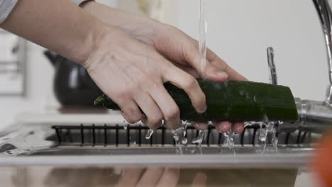 close slow motion shot as washing vegetables at the sink reflection on the counter