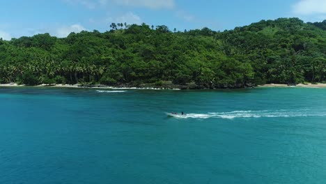 boating at playa colorado - people on boat sailing in blue sea leaving wake on water surface in dominican republic