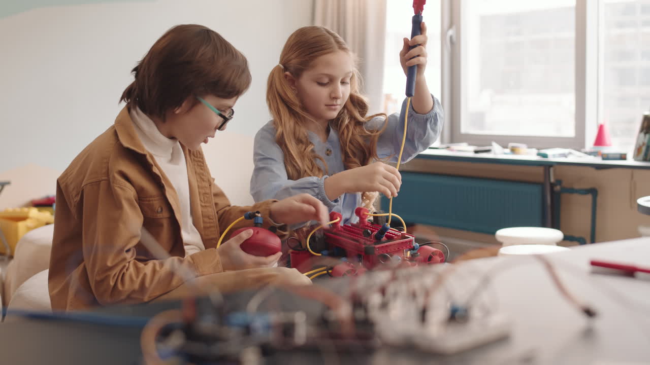 Caucasian Schoolgirl and Schoolboy Building Robot