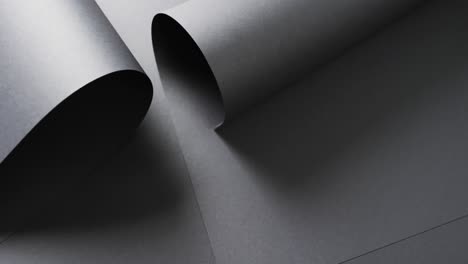 Close-up-of-rolls-of-black-paper-and-copy-space-on-black-background