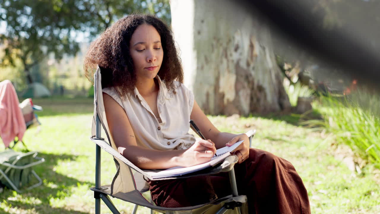 Camping, morning and a woman writing in a book