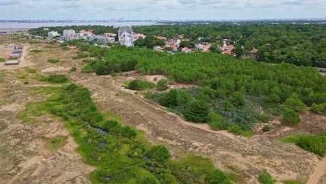 Slow forward drone movement near the coastal Saint-Brevin-les-Pins commune with Ferris wheel and green forested area in beachside, Loire-Atlantique, France