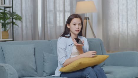 집에서 스마트폰으로 이야기하는 여성