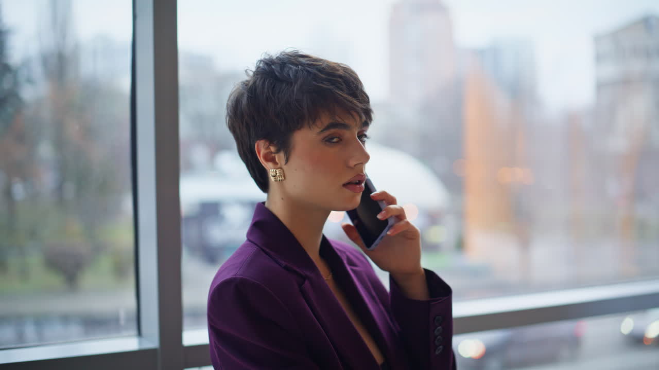 Elegant woman calling smartphone office window portrait. Serious business lady