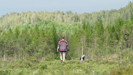 Hombre-Caminando-Con-Malamute-De-Alaska-En-El-Bosque-En-Indre-Fosen,-Noruega