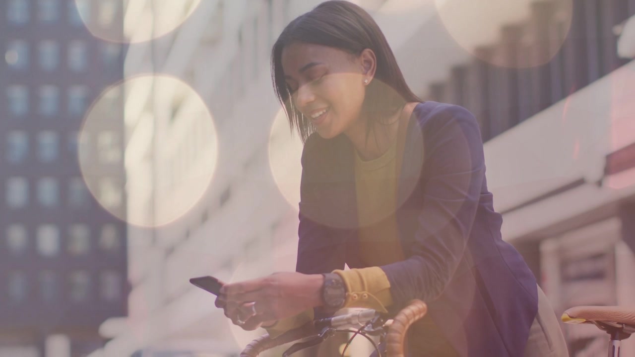 女性が自転車に座って通勤ルートのためにスマートフォンを操作している。ボケのオーバーレイがフレーム全体に漂う。
