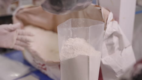 measure and weighting white wheat flour, portioning flour in plastic bag, packaging of wheat flour