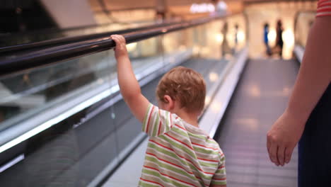 little boy rises on the escalator