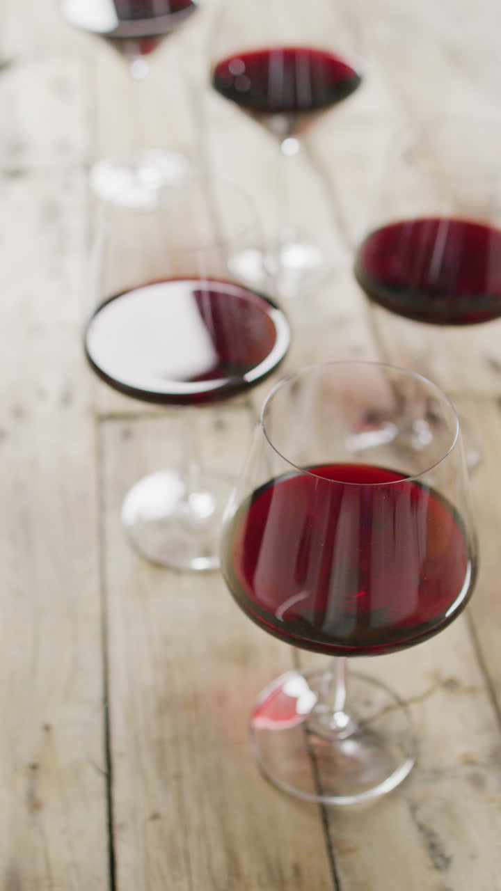 Video verticale di vino rosso nei bicchieri su un tavolo di legno