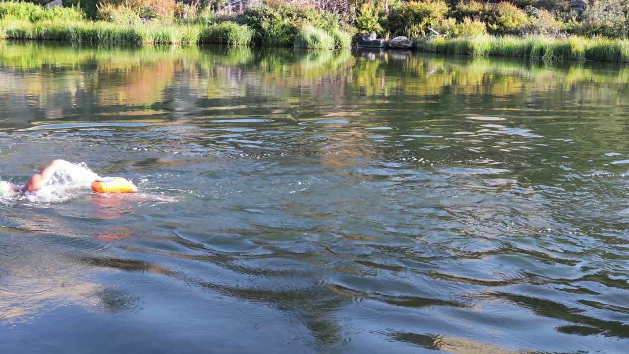 오른쪽에서 왼쪽으로 프레임을 통과하는 결정된 수영 선수의 중간 샷