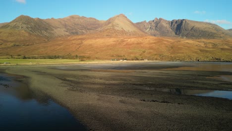 flying low over beach towards red cuillin mountains at sunset at glenbrittle isle of skye scotland