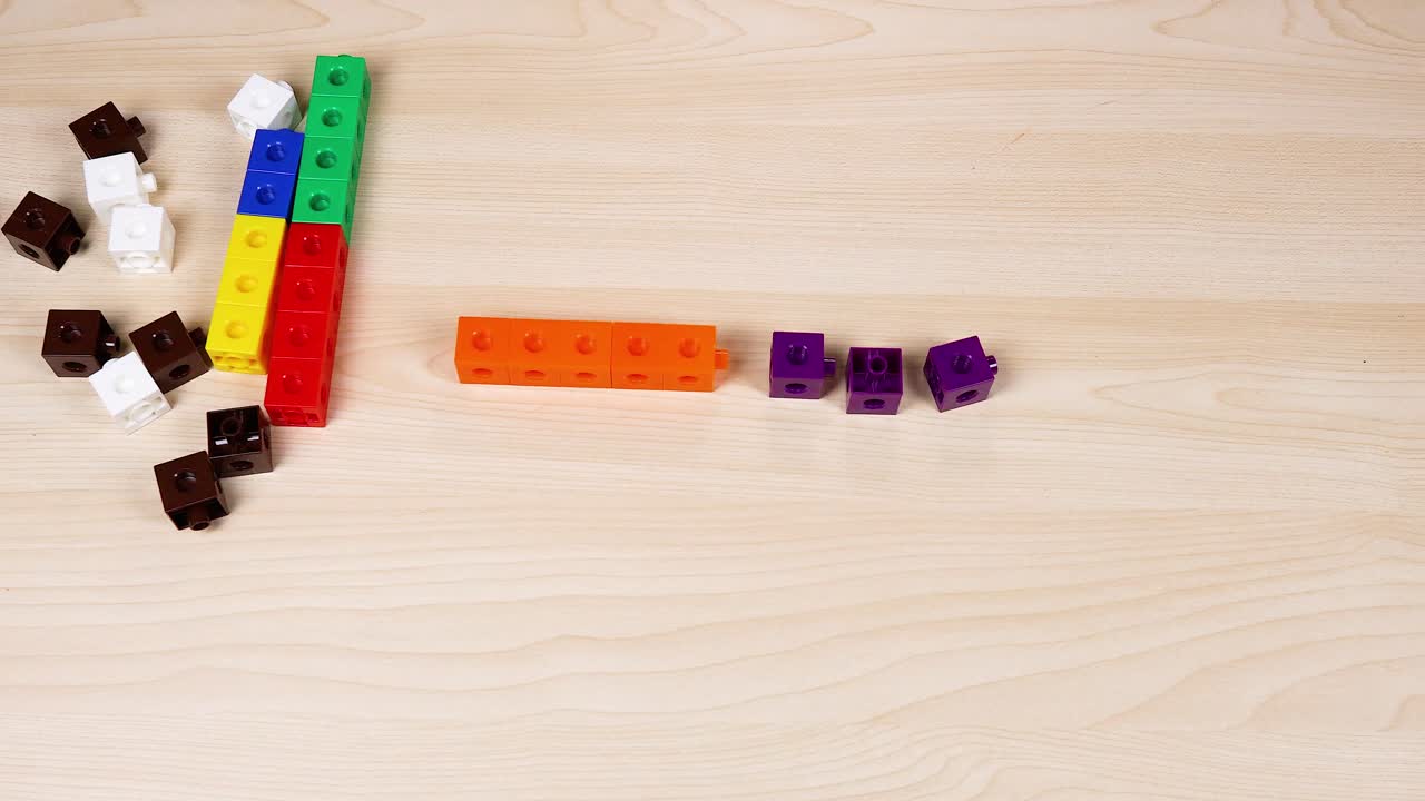 손 은 테이블 에 다채로운 큐브 를 조립 하고 있다