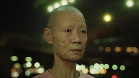 old asian woman in city at night