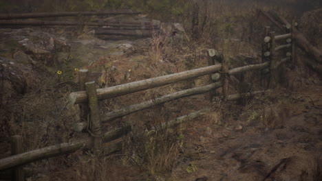 an old wood fence with a country field behind it