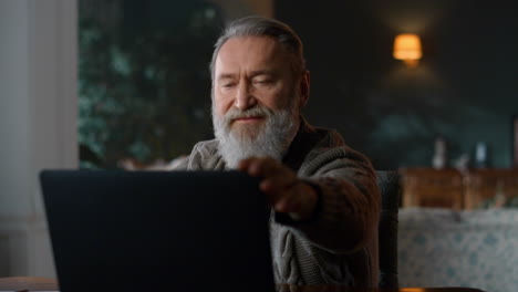 senior business man using laptop in cozy living room. senior man working home