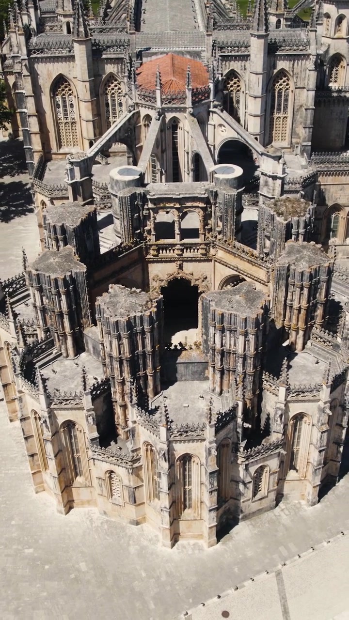 Panoramica aerea verticale attorno al monumento delle Capelas Imperfeitas a Batalha, Portogallo.