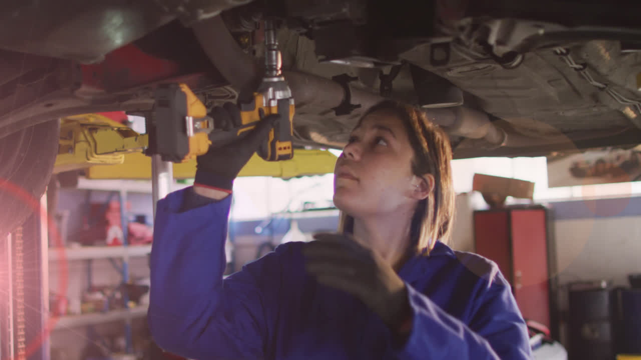 animación de puntos de luz sobre una mujer biracial reparando un coche
