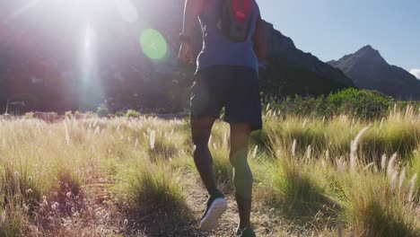 Hombre-Afroamericano-Corriendo-A-Campo-Traviesa-En-El-Campo-En-Una-Montaña