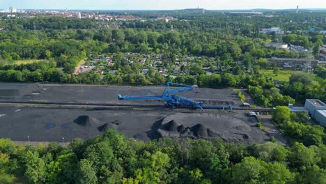 spreader reclaiming coal excavator at a coal terminal near residential area. majestic aerial view flight drone shot from above