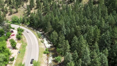 coches conduciendo por una carretera del cañón junto a un arroyo