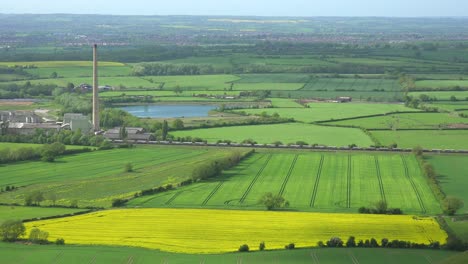 A-freight-train-passes-through-the-fertile-green-countryside-of-England-near-a-power-plant