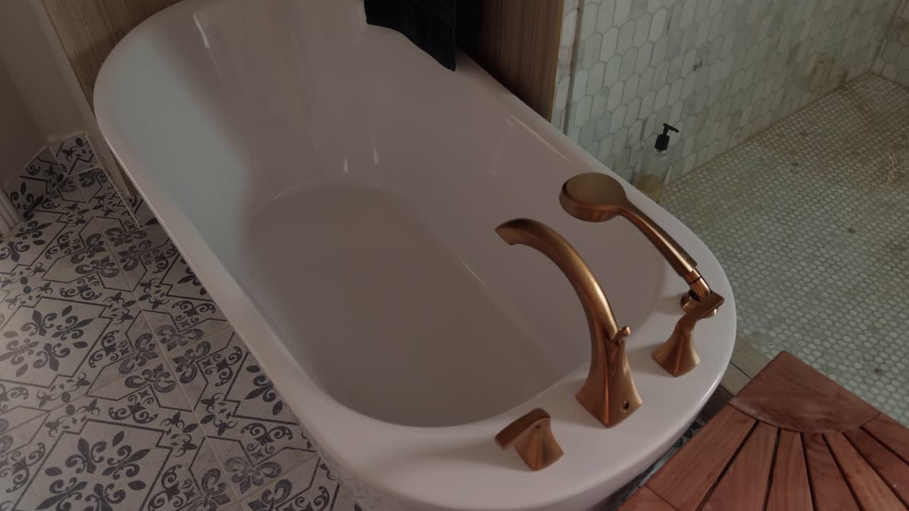 Steady pan across bathtub and glass shower in clean modern bathroom