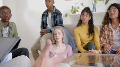 Thoughtful-diverse-group-of-teenage-friends-using-tablet-and-talking-at-home,-slow-motion