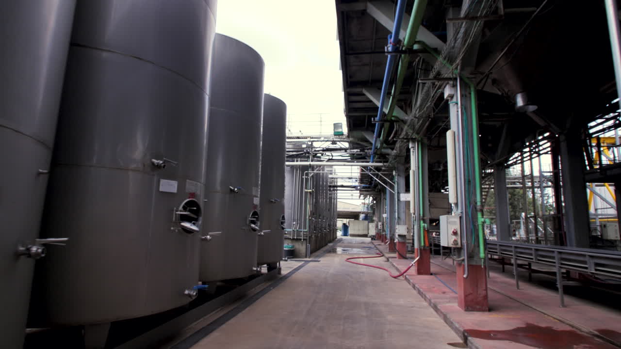 muchas filas de tanques de acero de tamaño mediano para vino en una bodega