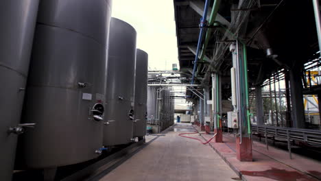 many rows of medium-sized steel tanks for wine at a winery