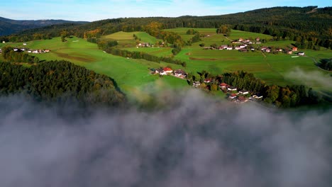 Ländliches-Dorf-In-Einem-Tal,-Eingehüllt-In-Dichten-Nebel,-Der-Die-Unteren-Teile-Der-Häuser-Verdeckt-Und-Eine-Dunstige-Schicht-über-Der-Szene-Erzeugt