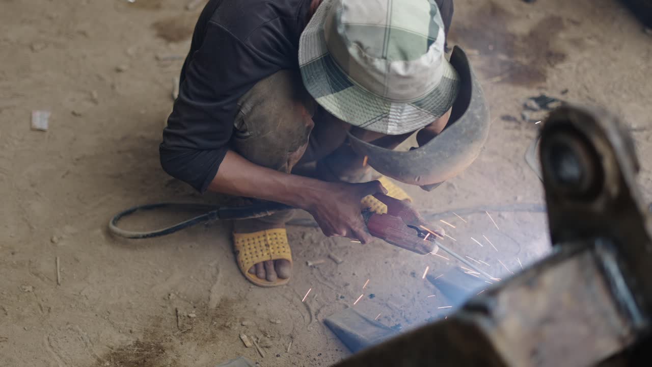 Worker Welding Metal Part