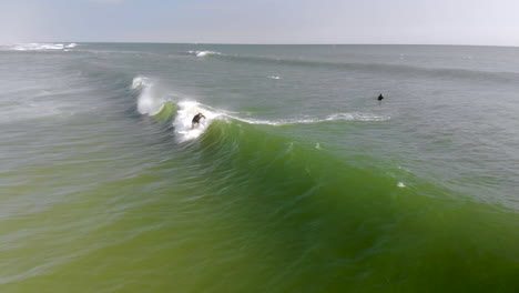 Epische-Drohnenfahrt-Eines-Surfers,-Der-Auf-Einer-Welle-Reitet