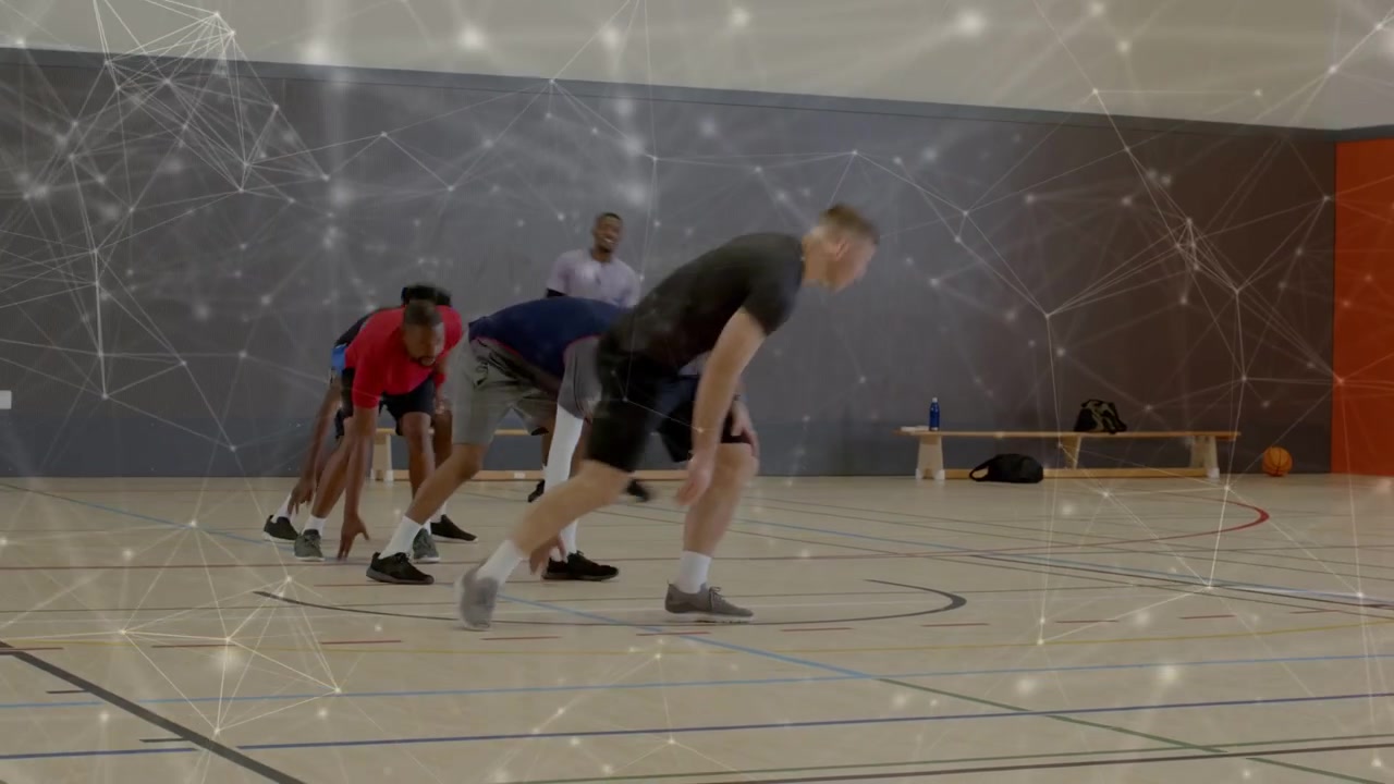 Five male basketball players picking up ball and practicing team agility drills across court lanes