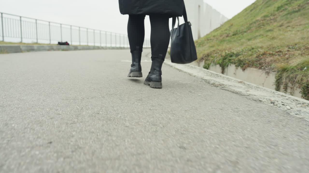 Zapatos de ciudad marchan. Calzado urbano avanza consistentemente. Calzado oscuro avanza constantemente siguiendo el ritmo de la ciudad. Botas de ciudad marchan sistemáticamente al ritmo de la percusión urbana.