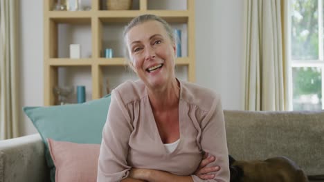 Portrait-of-happy-senior-caucasian-woman-sitting-and-making-video-call-with-cat-in-living-room