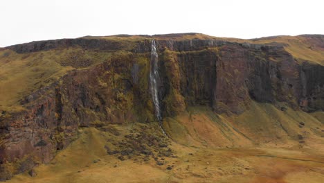 Riesige-Felsklippe-Mit-Drífandi-Wasserfall-In-Rauer-Nordischer-Landschaft