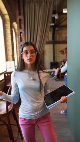 teenage girl holding tablet in a cafe or library