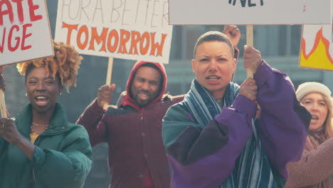 grupo de manifestantes con pancartas cantando consignas en la marcha de manifestación contra el cambio climático