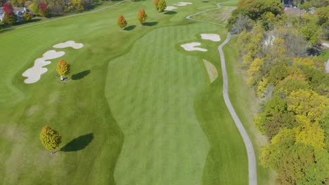 aerial establishing shot of private country club golf course in fall