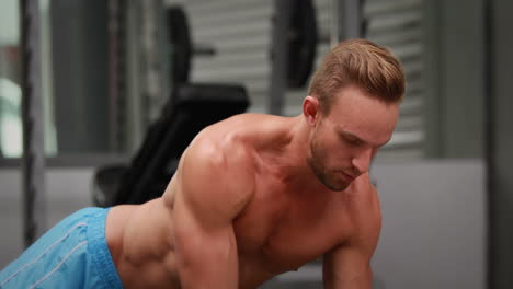 man doing dumbbell rows at crossfit gym