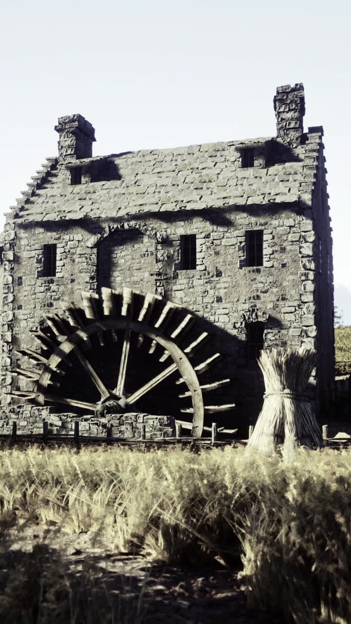 Historic watermill surrounded by fields in a rural landscape during daylight