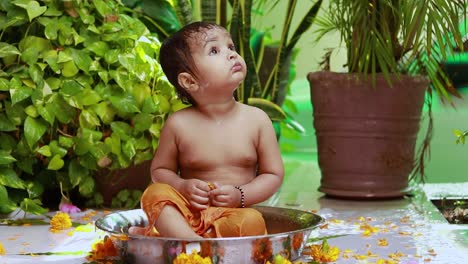 cute toddler baby boy bathing in decorated bathtub at outdoor from unique perspective